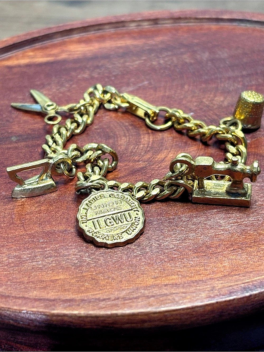 Vintage gold tone charm bracelet with garment/sewing charms, approx 6.25